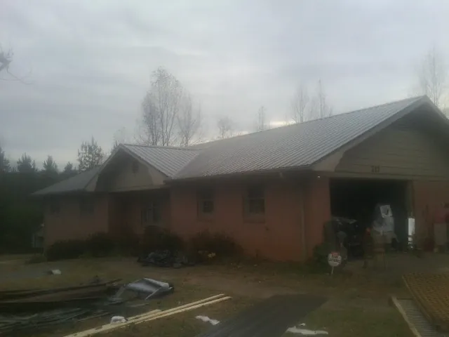 Gray metal roof on a stucco house with an attached garage in Endicott