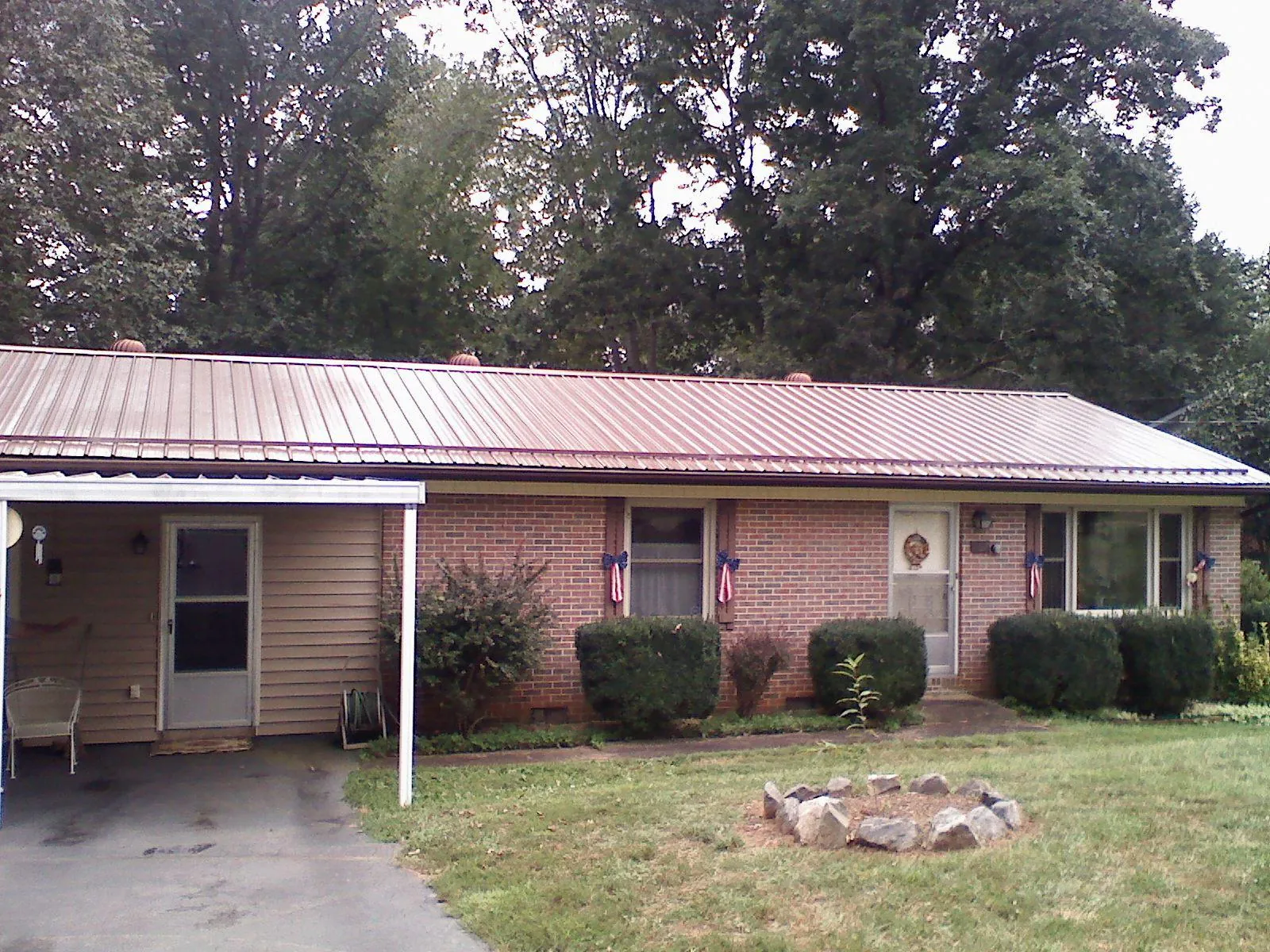 Bronze metal roof and carport on a brick ranch home — Roof Repair work by our crew in Endicott